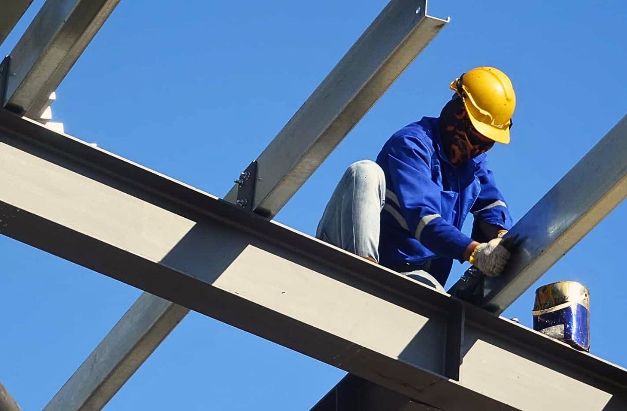 Công nhân đang thực hiện lắp đặt xà gồ trên mái nhà xưởng, đảm bảo an toàn lao động.